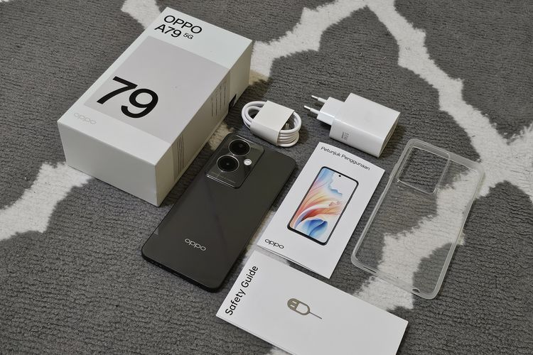 Isi kotak penjualan Oppo A79 5G yang meliputi unit ponsel, kabel data USB-A ke USB-C, adapter charger 33 watt, buku panduan dan keselamatan, jelly softcase, dan SIM ejector.