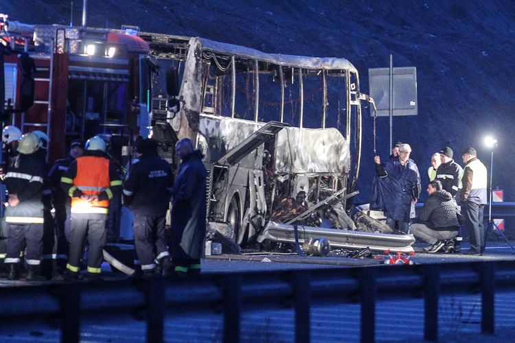Petugas penyelamat bekerja di sekitar lokasi bus yang terbakar di jalan raya ekat esa Bosnek, selatan Sofia, Bulgaria,pada 23 November 2021. Sebanyak 45 orang termasuk anak-anak tewas dalam insiden itu.