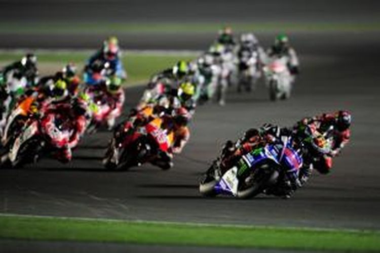 Pebalap Movistar Yamaha asal Spanyol, Jorge Lorenzo (depan), memimpin rombongan pebalap MotoGP pada GP Qatar di Sirkuit Losail, Minggu (23/3/2014).