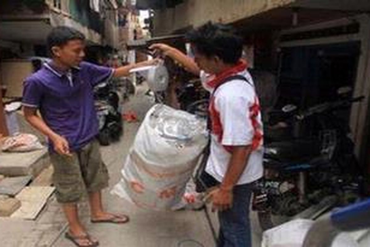 Petugas menimbang sampah warga untuk kemudian ditaksir harganya di Kelurahan Kapuk Muara, Kecamatan Penjaringan, Jakarta Utara, Kamis (6/12/2012). Rintisan bank sampah di kelurahan itu membantu warga menangani sampah rumah tangganya.
