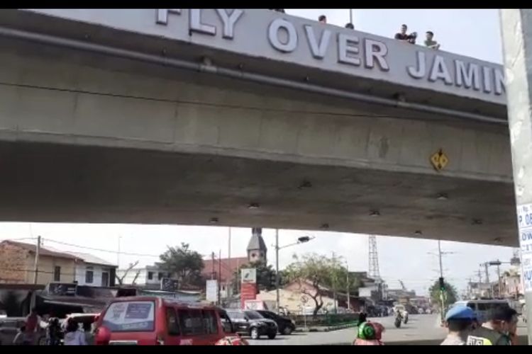 Tangkapan layar video yang merekam sejumlah orang berdiri di atas jembatan layang (fly over) di Jalan Jamin Ginting Medan, Kamis siang (30/1/2020). Pada pagi tadi, seorang pria berjaket dan mengenakan seragam polisi diduga melompat dari atas jembatan dan membuat heboh warga yang melintas di jalan tersebut.