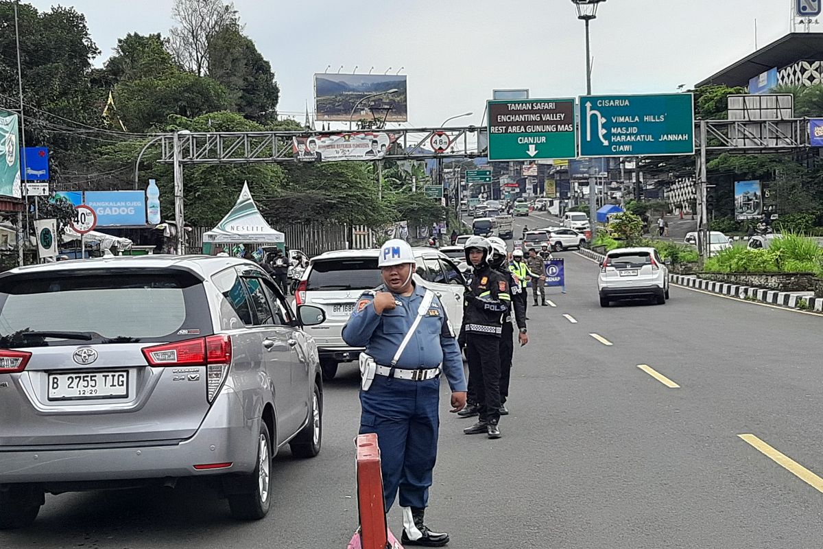 Petugas gabungan berjaga dan memeriksa pelat nomor ganjil genap di Jalur Wisata Puncak Bogor, Jawa Barat, Senin (27/1/2025).