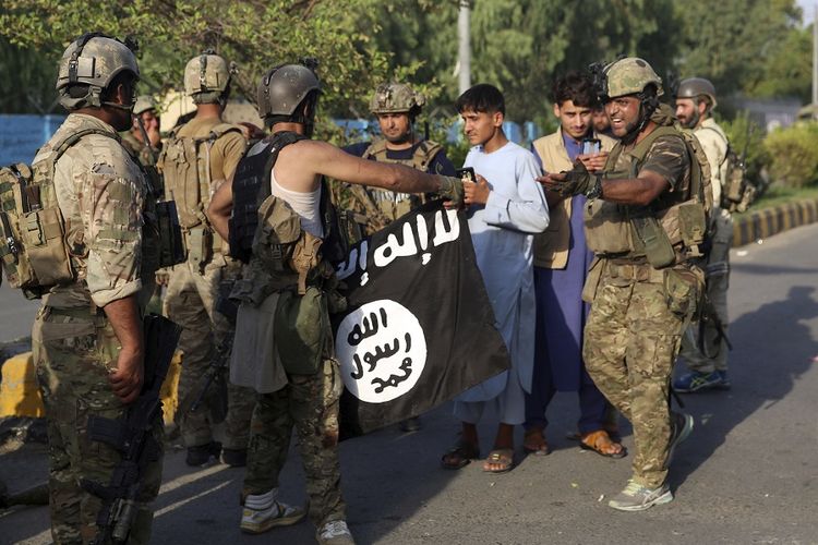 Tentara Afghanistan memegang bendera kelompok ISIS setelah sebuah serangan di kompleks tahanan di Kota Jalalabad, Afghanistan, Senin (3/8/2020). Serangan tersebut membuat puluhan orang tewas dan ratusan tahanan melarikan diri.