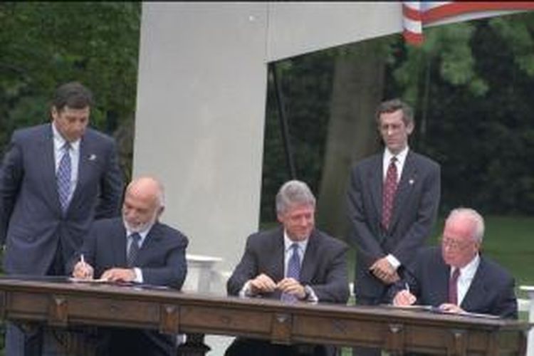 Presiden AS Bill Clinton menyaksikan Raja Jordania Hussein (kiri) dan PM Israel Yitzak Rabin (kanan) membubuhkan tanda tangan di atas dokumen perjanjian damai yang diteken pada 26 Oktober 1994.