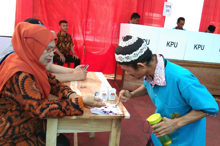 Salah seorang warga binaan Lapas Kelas II A Karawang tengah mencelupkan jari ke tinta sebagai tanda telah mencoblos, Rabu (17/4/2019).