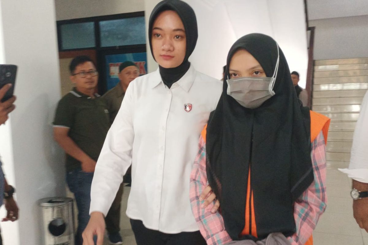 Karyawati Bank Jambi Kantor Cabang Kerinci, RS (26) digiring petugas saat akan melakukan konferensi pers di Mapolda Jambi, Senin (2/6/2025). RS ditetapkan sebagai tersangka pembobolan rekening nasabah hingga Rp7,1 miliar.