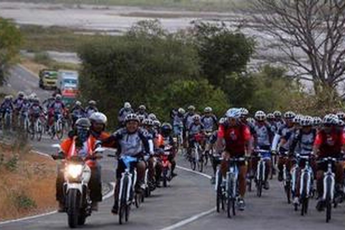 Peserta Jelajah Sepeda Bali Komodo melalui jalanan berbukit di kawasan Poto Tano, Sumbawa Barat, menuju garis finish etape II di Alas, Sumbawa, Nusa Tenggara Barat, Rabu (19/9/2012). Pada etape II, peserta menempuh jarak 112 kilometer yang dimulai dari Senggigi, Lombok.  