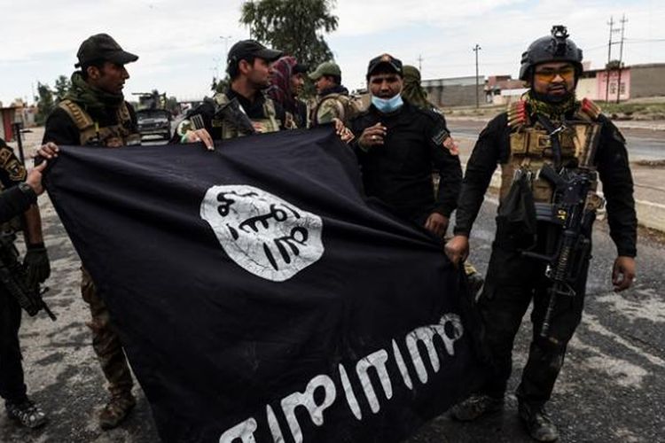 Tentara Irak memperlihatkan bendera ISIS yang diperoleh setelah mereka merebut pertahanan ISIS di sebuah desa di sisi timur kota Mosul.