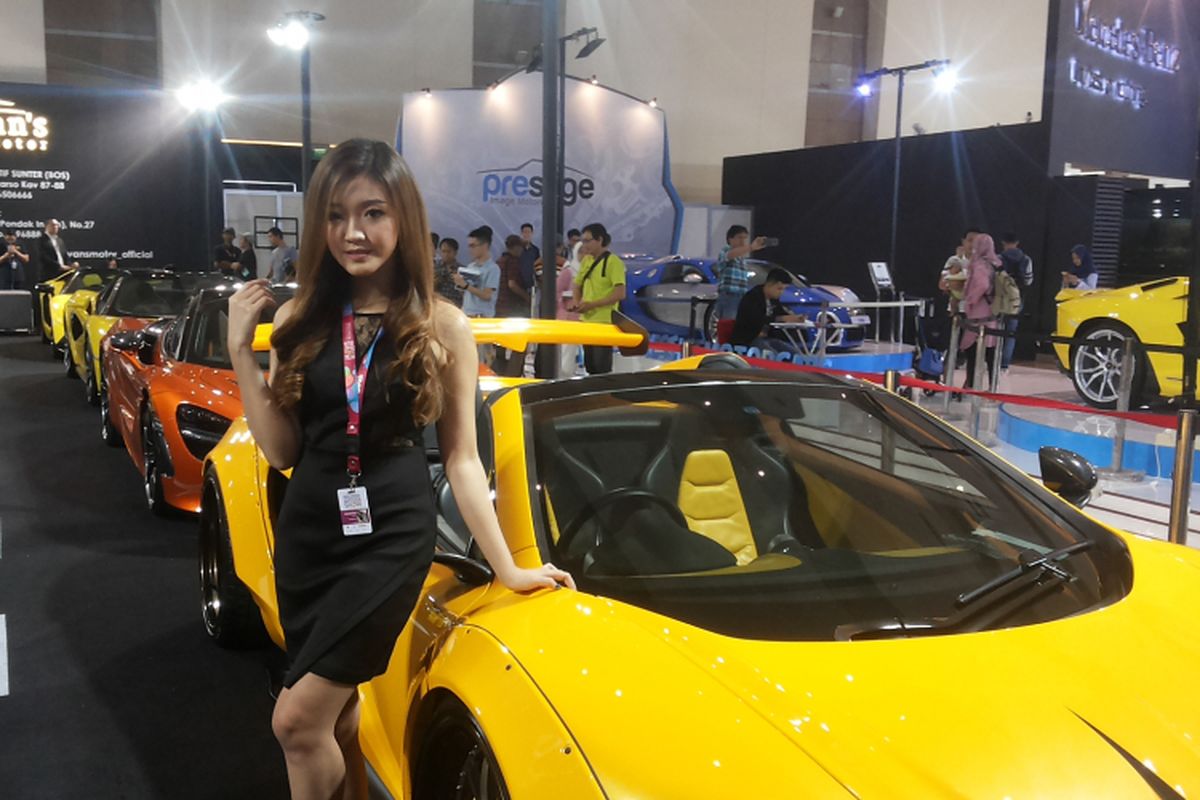 Seorang sales promotion girl sedang berpose di depan deretan mobil premium yang dipamerkan di stan Ivans Motor pada hari ketiga berlangsungnya ajang Indonesia International Motor Show (IIMS) 2018 di JIEXpo, Kemayoran, Jakarta, Sabtu (21/4/2018).