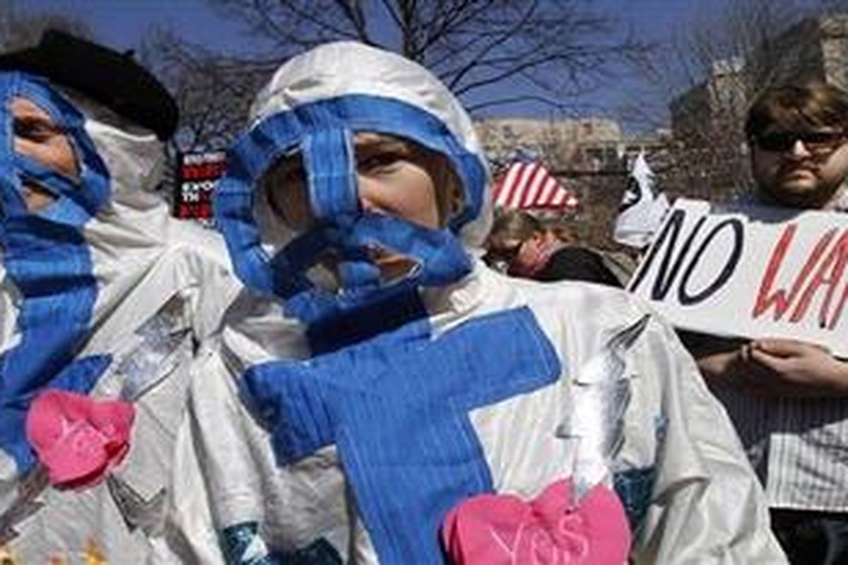 Scott Points (left) dan Gretchen Elsner berbusana sebagai "hantu damai" saat demonstrasi anti perang dekat Gedung Putih di Washington, 19 Maret 2011 dalam rangka peringatan delapan tahun invasi ke Irak. 