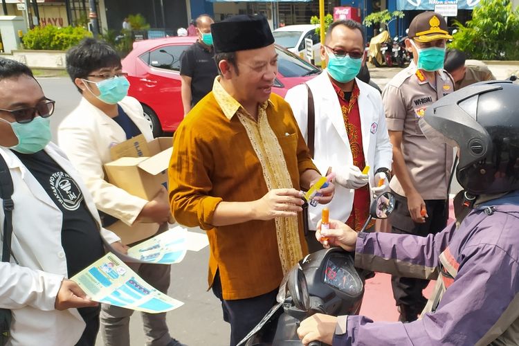 Bupati Banyumas Achmad Husein membagikan handsanitizer yang diproduksi anggota Ikatan Apoteker Indonesia (IAI) Banyumas kepada pengguna jalan di Purwokerto, Kabupaten Banyumas, Jawa Tengah, Kamis (19/3/2020).