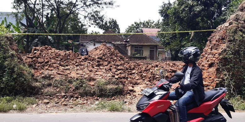 Pengendara sepeda motor melintas di tembok Benteng Karaton Kartasura yang dijebol di Kampung Krapyak Kulon RT 002/RW 010, Kelurahan Kartasura, Kecamatan Kartasura, Sukoharjo, Jawa Tengah, Sabtu (23/4/2022).