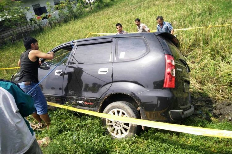 Warga dan polisi mengangkat mobil avanza yang terguling di areal persawahan Desa Tunong, Kecamatan Muara Batu, Kabupaten Aceh Utara, Selasa (30/5/2017). Sopir mobil ini melarikan diri setelah menabrak warga di lokasi kejadian