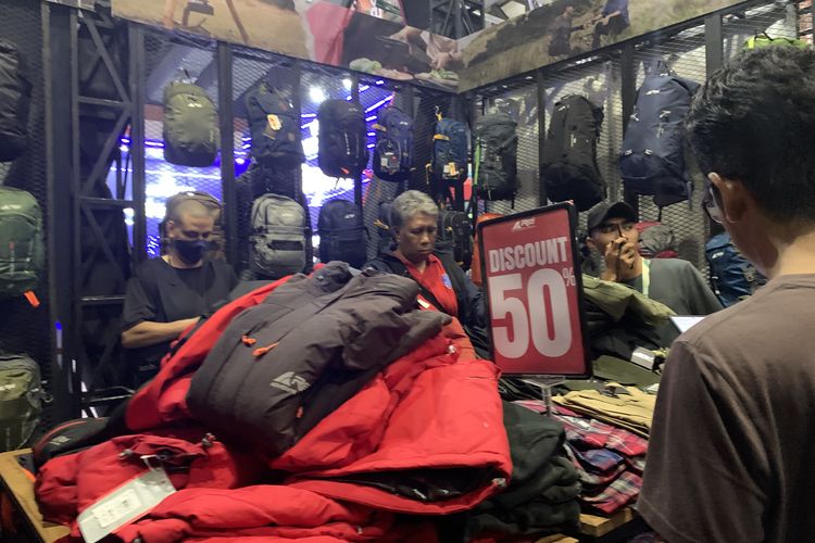 Arei menyediakan diskon 50 persen untuk produk jaket gunung tertentu yang ditumpuk dalam keranjang di Indofest 2025. Kebanyakan jaket gunung Arei berwarna merah dan hitam. 