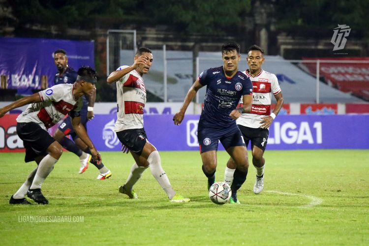 Pemain Arema FC M Rafli dijaga ketat pemain Madura United saat pertandingan pekan 26 Liga 1 2021-2022 yang berakhir dengan skor 1-0 di Stadion I Gusti Ngurah Rai Denpasar, Jumat (18/2/2022) malam.