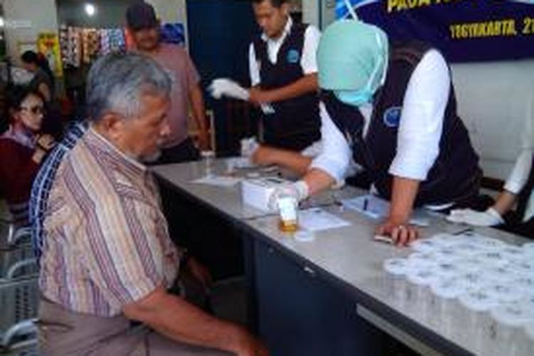 Petugas BNNP DIY saat mengetes urine sopir bus di terminal Giwangan