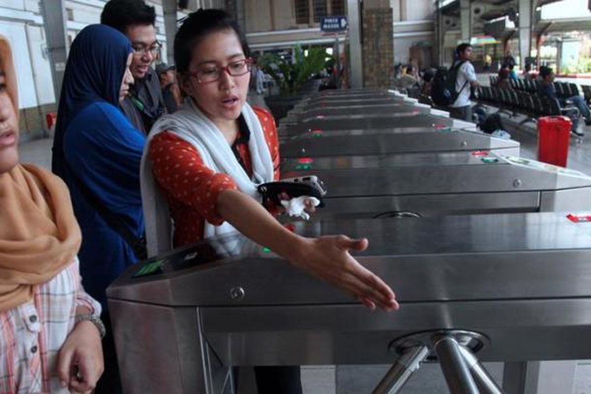 Petugas memandu penumpang KRL menggunakan tiket elektronik jurusan Jakarta Kota-Depok di Stasiun Jakarta Kota, Jakarta Barat, Kamis (25/4/2013). Uji coba itu dilakukan untuk memastikan kesiapan sistem menjelang penggunaan tiket elektronik pada Juni nanti.
