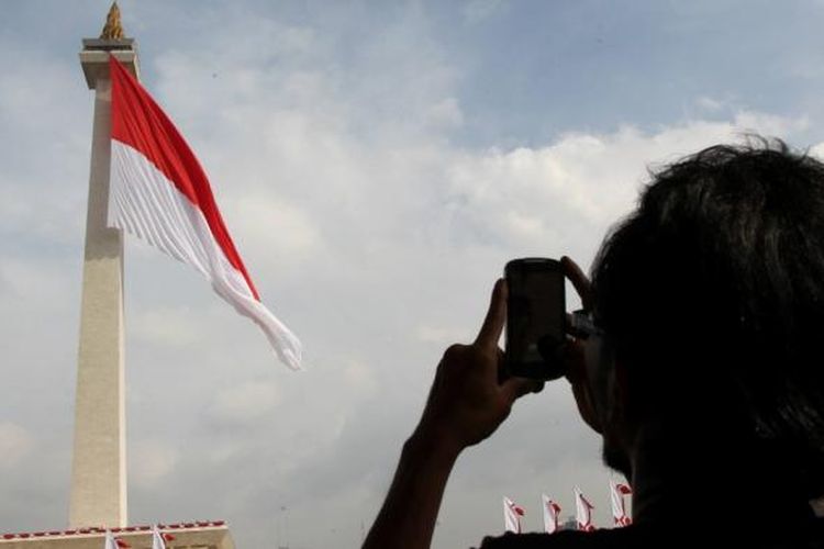 Bendera Merah Putih raksasa dikibarkan oleh anggota TNI dan anggota Pramuka di Tugu Monas, Jakarta, Jumat (19/12/2014). Pengibaran bendera Merah Putih tersebut merupakan puncak peringatan Hari Bela Negara sekaligus tercatat dalam rekor dunia dengan kategori bendera terbesar di dunia dengan ukuran 2.250 meter persegi.