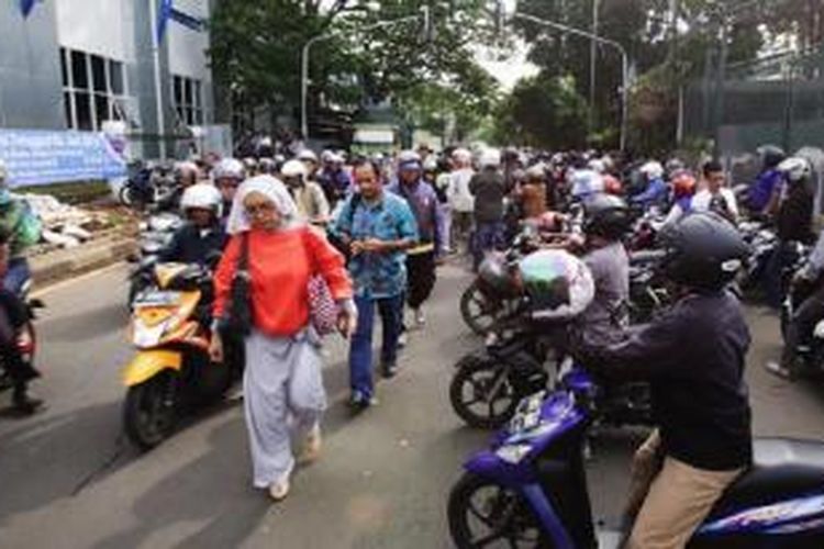 Tukang ojek berlomba mendapatkan penumpang yang baru keluar dari kereta di Stasiun Palmerah, Jakarta, Jumat (5/6). Kondisi ini terjadi setiap pagi saat jam berangkat kerja. Tukang ojek pun bersaing menempatkan sepeda motor hingga ke tengah jalan sehingga mengganggu kelancaran lalu lintas. 