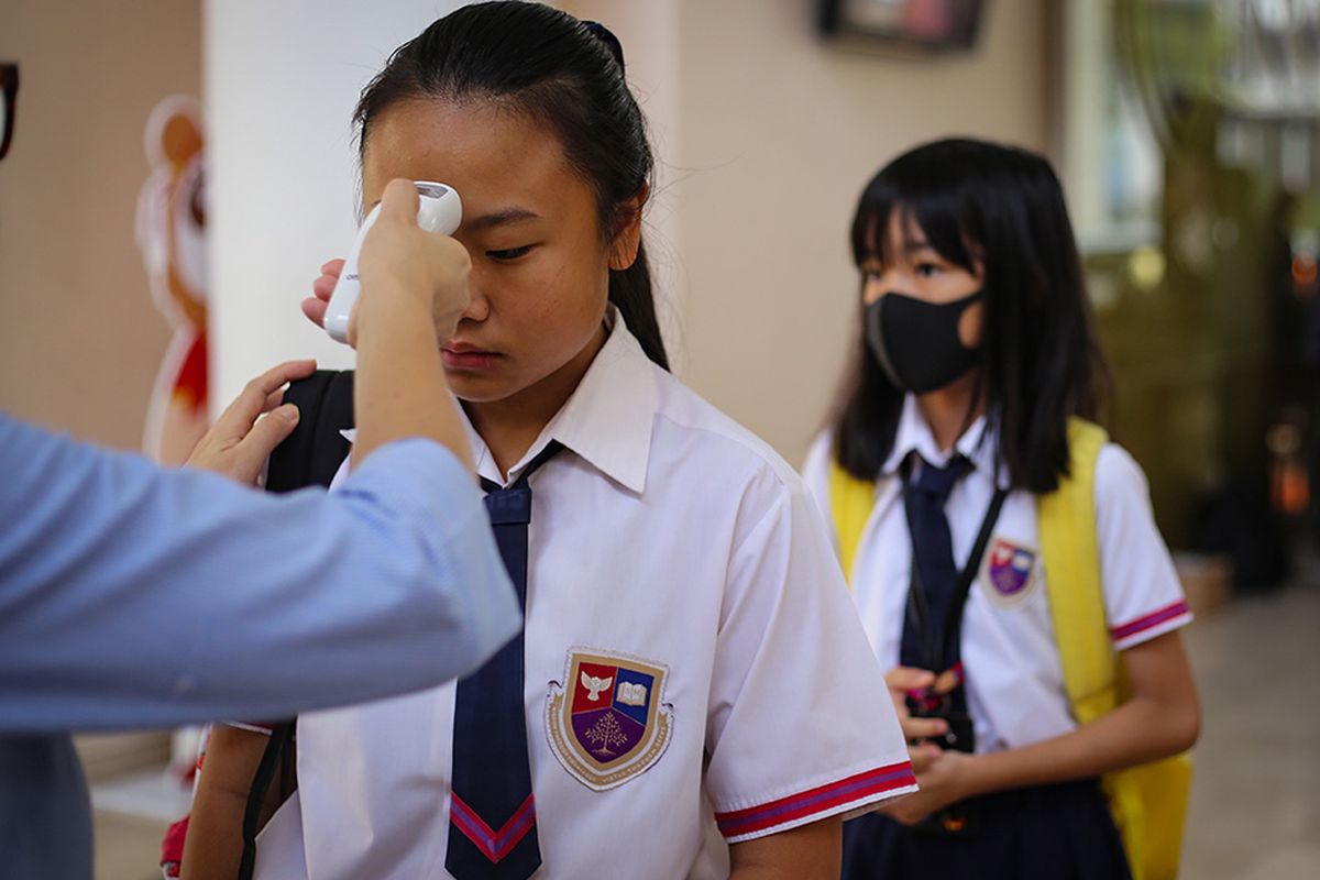 Siswa sekolah menjalani pemeriksaan suhu tubuh sebelum memasuki lingkungan sekolah di Jakarta Nanyang School, Tangerang, Banten, Rabu (4/3/2020). Pemeriksaan kondisi suhu tubuh di sekolah tersebut untuk mengantisipasi penyebaran virus menular dan siswa yang melibihi suhu lebih dari 37 derajat akan dipulangkan.
