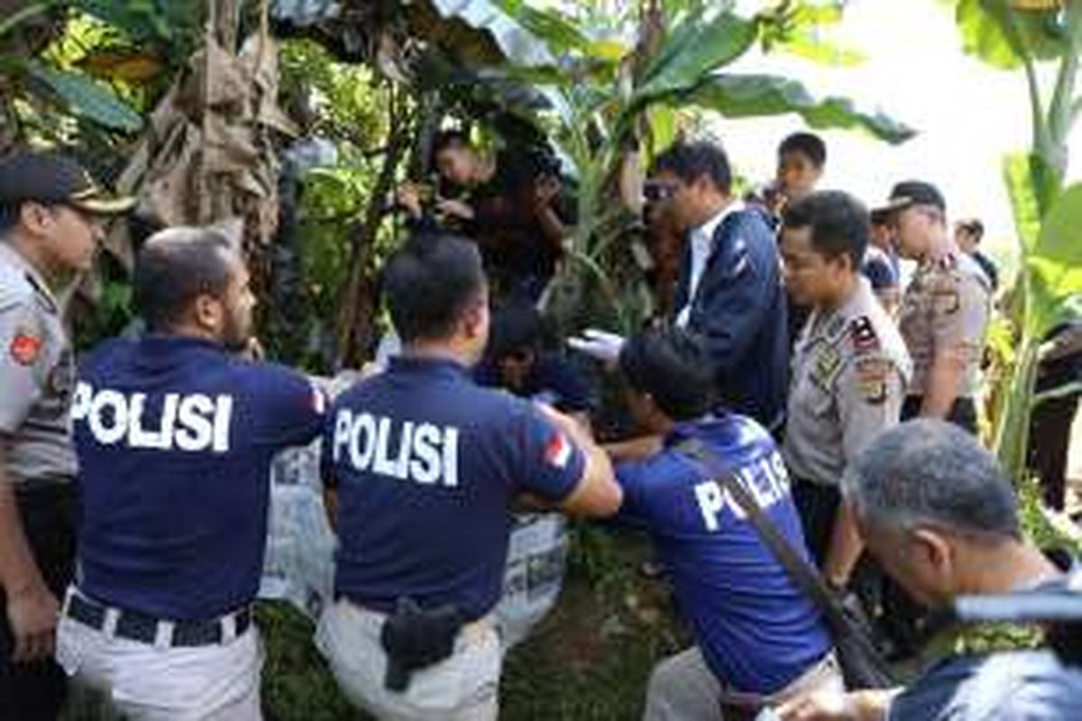 Polisi mengamankan tempat ditemukannya mayat laki-laki tanpa identitas di kebun pisang Jalan Kampung Ciater, Lengkong Wetan, Serpong, Tangerang Selatan, Selasa (26/7/2016). Mayat ditemukan dalam kondisi terbakar dan terbungkus kain sarung.