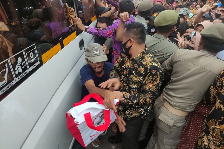 Antrean warga memadati mobil yang dijadikan untuk bagi-bagi sembako di Pasar Gunung Batu, Kota Bogor, Jawa Barat, Selasa (17/5/2022). Aksi dorong antar warga dan petugas sempat mewarnai pembagian sembako.