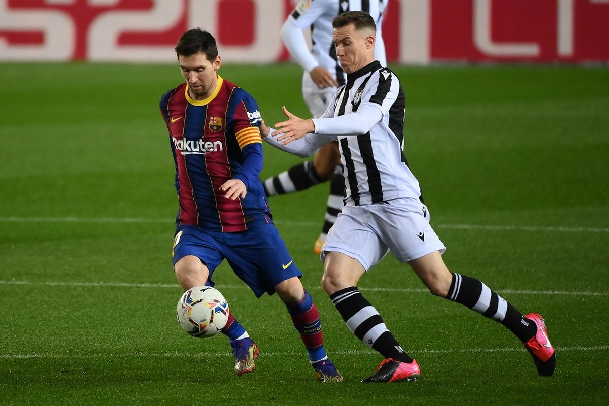 Bek Spanyol Levante Carlos Clerc (kanan) menantang penyerang Argentina Barcelona Lionel Messi selama pertandingan sepak bola liga Spanyol antara FC Barcelona dan Levante UD di stadion Camp Nou di Barcelona pada 13 Desember 2020