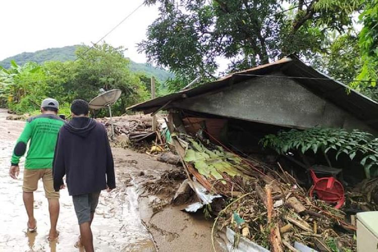 Warga melintas di dekat rumah yang rusak akibat banjir bandang di Adonara Timur, Flores Timur, NTT, Senin (5/4/2021). Berdasarkan data BNPB hingga senin siang, korban meninggal dunia akibat banjir bandang di Flores Timur mencapai  68 jiwa. ANTARA FOTO/Pion Ratuloli/wpa/wsj.