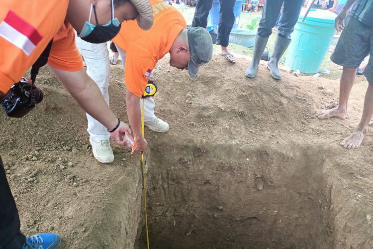 Aparat kepolisian saat membongkar makam Sukardin (34), warga Dusun Dewa Rangga, Desa Samili, Kecamatan Woha, Kabupaten Bima, untuk keperluan autopsi, Jumat (27/5/2022).