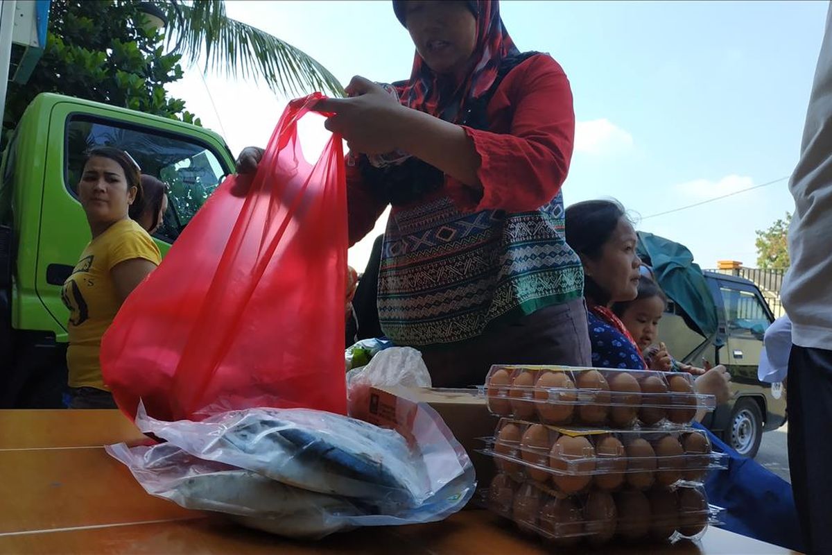 Seorang warga Rusunawa Tipar Cakung, Jakarta Timur tampak membereskan pangan murah, Selasa (18/6/2019).