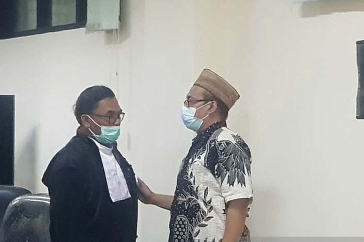 Dosen UIN Semarang Amin Farih (kanan), terdakwa dalam kasua suap seleksi perangkat desa di Kabupaten Demak, berkonsultasi dengan penasihat hukumnya usai sidang di Pengadilan Tipikor Semarang, Senin (17/10/2022).