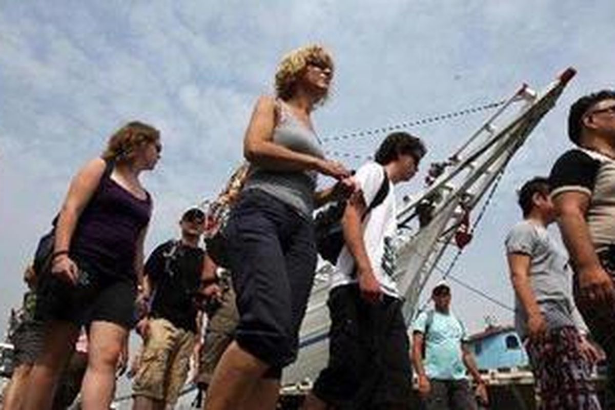 Wisatawan asal Belanda tengah mengamati aktivitas anak buah kapal phinisi yang sedang melakukan bongkar muat di Pelabuhan Sunda Kelapa, Jakarta, Minggu (25/7/2010).