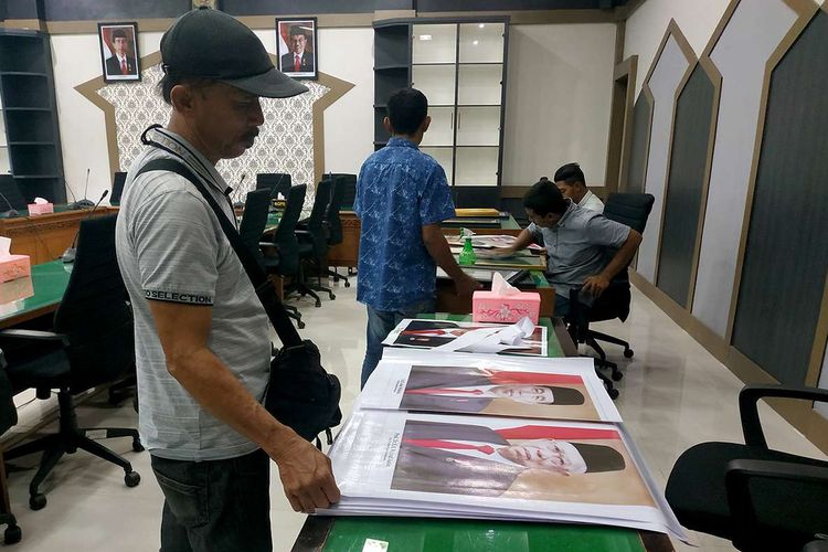 Pekerja di ruang Badan Anggaran DPR Aceh mempersiapkan foto Presiden dan Wakil Presiden Joko Widodo-Maruf Amin yang tercetak dari bahan spanduk, untuk dipanjang di setiap ruang di Gedung DPR Aceh, Kamis (24/10/2019). Sekretaris Dewan DPR Aceh Suheimi saat dikonfirmasi mengaku tidak mengetahui perihal percetakan dan pemasangan foto presiden dan wakil presiden dari bahan spanduk tersebut, dan menurutnya itu dilakukan atas inisiatif pekerja bagian kebersihan yang tidak berkoordinasi dengan bagian kesekretariatan.