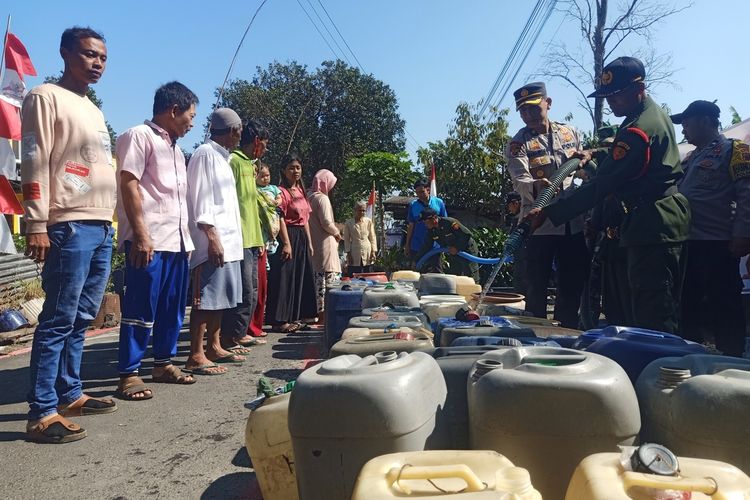 Petugas kepolisian Polres Pemalang membantu proses droping air bersih untuk warga Dusun Krajan, Desa Belik, Kabupaten Pemalang