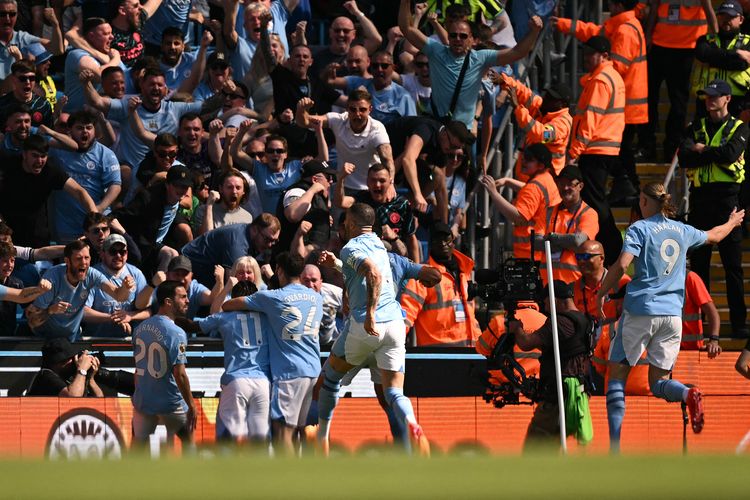 Gelandang Manchester City Phil Foden dikerumuni oleh rekan satu timnya setelah mencetak gol pembuka pada pertandingan Liga Inggris antara Manchester City vs West Ham United di Stadion Etihad di Manchester, Inggris, pada 19 Mei 2024. (Foto oleh Oli SCARFF / AFP) /