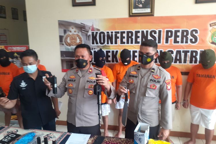 Kapolsek Medan Satria Kota Bekasi, Agus Rahmat memegang barang bukti penganiayaan satu keluarga di Bekasi, Senin (13/9/2021).