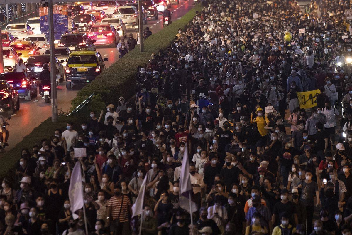 Hundreds of pro-democracy protesters march demanding the release of pro-democracy activists in Bangkok, Thailand, Wednesday, Feb. 10, 2021. Protesters demanded the government to step down, the constitution to be amended to make it more democratic and the monarchy be more accountable. (AP Photo/Sakchai Lalit)