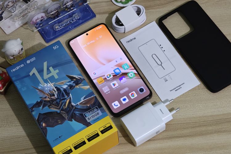 Kelengkapan kotak penjualan Realme 14 5G. Di dalamnya ada unit ponsel, adapter charger 45 watt, kabel data USB-A ke USB-C, buku panduan, kartu garansi, SIM ejector, dan casing berwarna hitam.