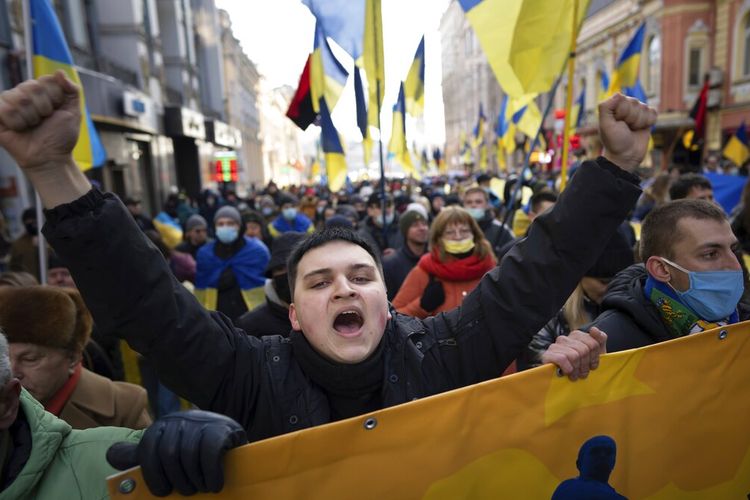 Demonstran dengan bendera nasional Ukraina, salah satunya berteriak, berdemonstrasi menentang agresi Rusia di pusat Kharkiv, kota terbesar kedua di Ukraina, Sabtu, 5 Februari 2022, hanya 40 kilometer (25 mil) dari beberapa dari puluhan ribu Pasukan Rusia berkumpul di perbatasan Ukraina. 