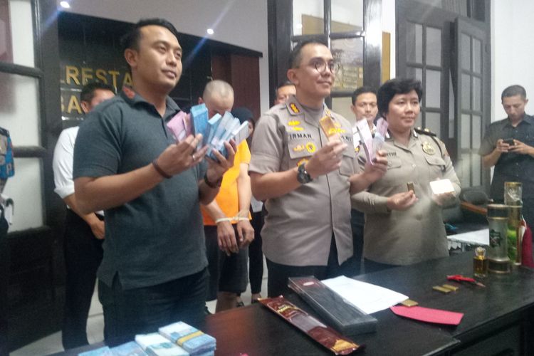 Kapolrestabes Bandung, Kombes Irman Sugema tengah memperlihatkan barang bukti uang dan batang emas palsu.