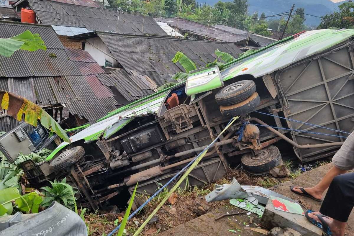 Bus pariwisata bernomor polisi DK 7359 AJ terperosok dan terguling menimpa rumah warga di Puncak, Bogor, Jawa Barat, Sabtu (3/8/2024).