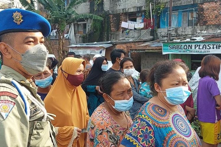 Ratusan warga di Rumah Susun (Rusun) 24 Ilir, Palembang, Sumatera Selatan mengantre untuk membeli satu liter minyak goreng dalam operasi pasar yang dilakukan oleh pemerintah setempat, Kamis (24/2/2022).