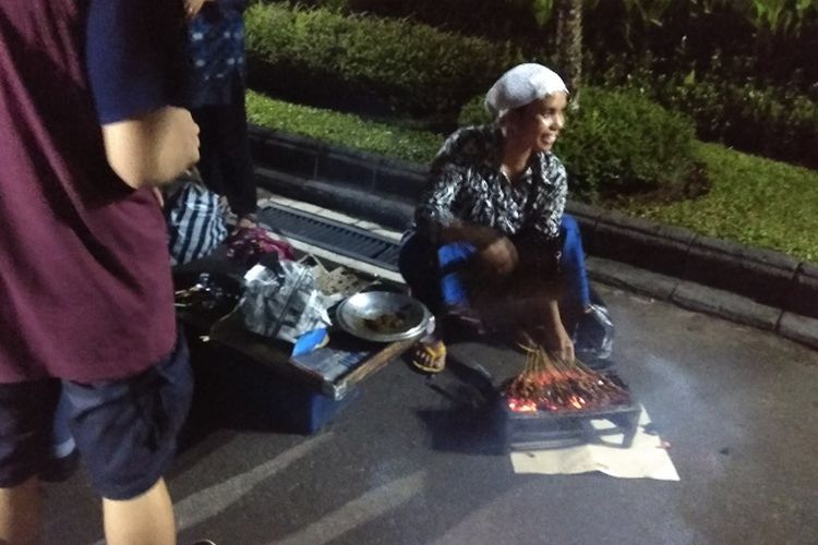 Penjual sate ayam di sekitar Kawasan Malioboro, Khotimah (25) menyiapkan sate ayam untuk pengunjung Gedung Agung Istana Kepresidenan, Yogyakarta, Minggu (31/12/2017). Pada malam tahun baru 2018, beberapa pedagang dan pengunjung Malioboro diajak masuk oleh Presiden Joko Widodo.