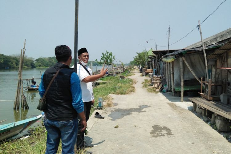 Kepala Desa Randuboto Andhy Sulandra (kanan), saat menunjukkan beberapa rumah warga di bantaran sungai yang bakal ditata, Rabu (1/9/2021).