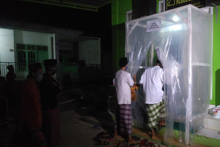 Jamaah Musala Nurul Ikhwan, Kelurahan Sumber Rejo, Kecamatan Kemiling, Bandar Lampung memasuki bilik disinfeksi sebelum melaksakan salat tarawih, Kamis (23/4/2020). Musala ini menerapkan protokol kesehatan bagi jamaah yang hendak mengikuti ibadah salat tarawih selama Ramadhan.