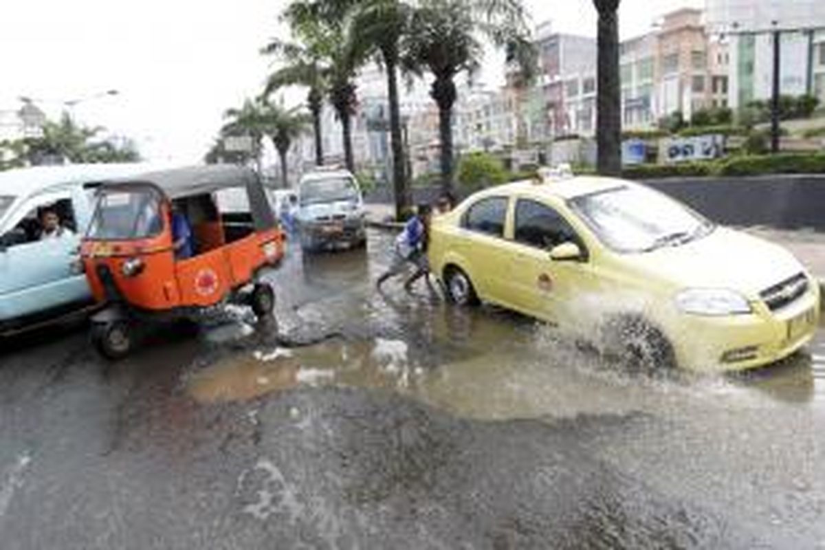 Kondisi jalan berlubang yang terdapat di Jalan Gunung Sahari, Jakarta Utara, Sabtu (1/2/2014). Banjir yang menggenangi Jakarta beberapa waktu lalu membuat sejumlah ruas jalan rusak dan kerap menyebabkan kemacetan dan kecelakaan lalu lintas.