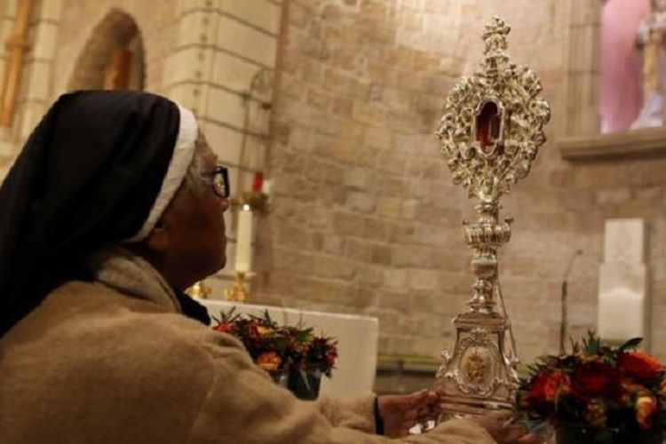 Seorang biarawati memperhatikan tongkat berisi potongan kayu yang diyakini berasal dari palungan Yesus. Setelah berada di Eropa lebih dari 1.000 tahun, potongan kayu tersebut bakal dikembalikan ke Betlehem.