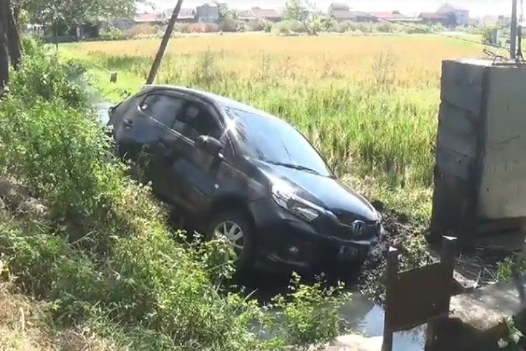 Mobil Honda Brio nomor B 2795 KON yang dikemudikan Sunaryo, 73, warga Desa Ngelang, nyungsep masuk parit di Jalan Raya Ngawi-Maospati, Desa Geneng, Kecamatan Geneng, Kabupaten Ngawi setelah diseruduk Bus Sugeng Rahayu nopol W 7499UP yang dikemudikan Agus Indria Utama (44) , warga Kelurahan Nambangan Kidul, Kecamatan Manguharjo, Kota Madiun.