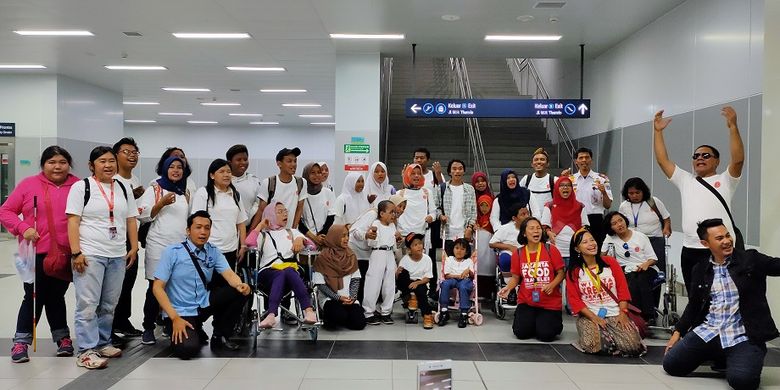 Para penyandang disabilitas bersama pemandu berfoto bersama di Stasiun MRT Bundaran HI, Jakarta, Selasa (3/12/2019).