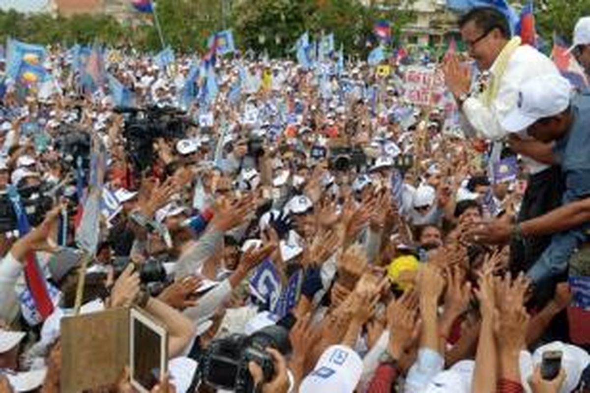 Pemimpin oposisi pada Partai Penyelamatan Nasional Kamboja (CNRP) Sam Rainsy (kanan) memberikan salam kepada pendukungnya di Taman Demokrasi dalam kampanye umum di Phnom Penh, Kamboja, Jumat (26/7/2013).